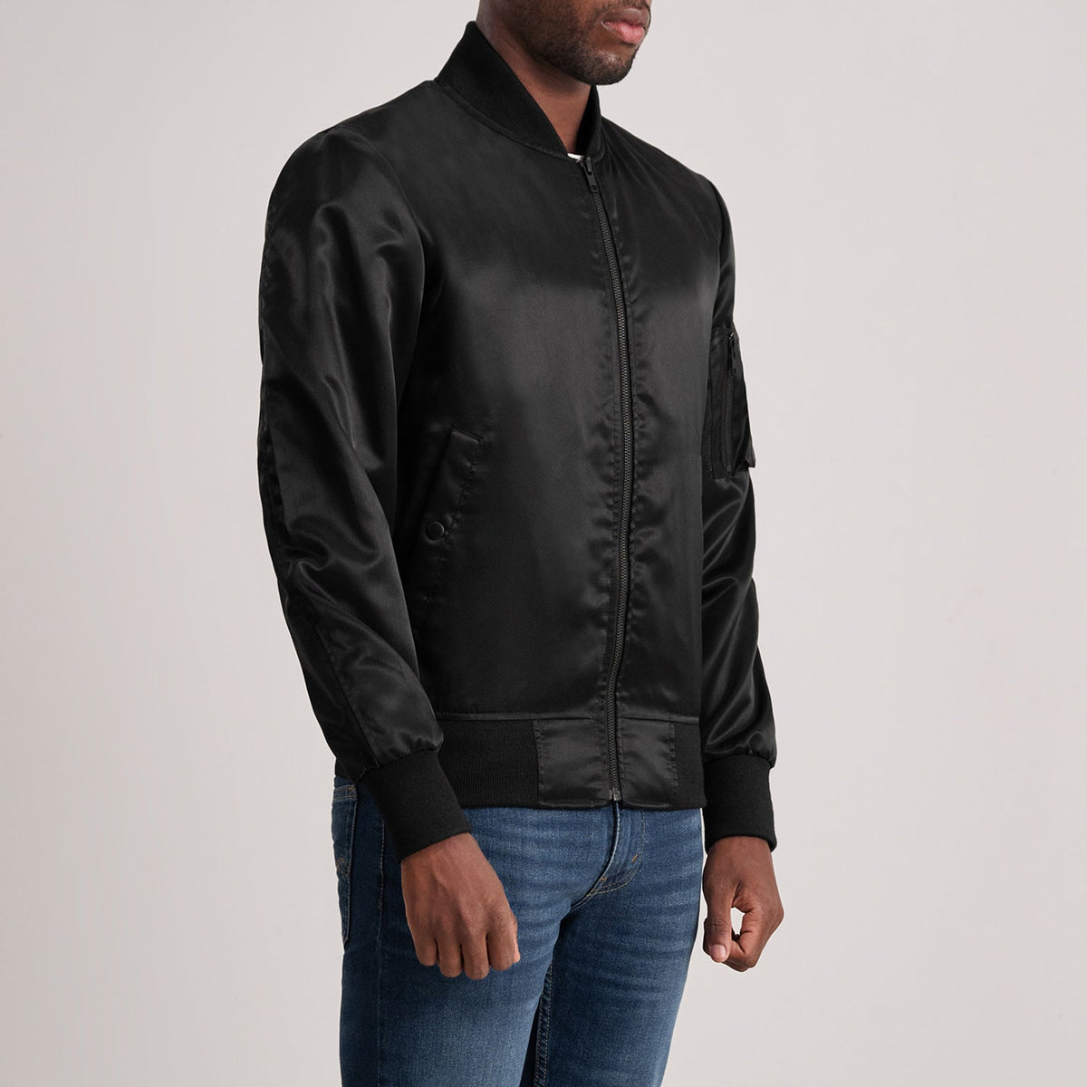 
Black Satin Bomber Jacket - Vista posterior con hombros definidos y bajo impecable